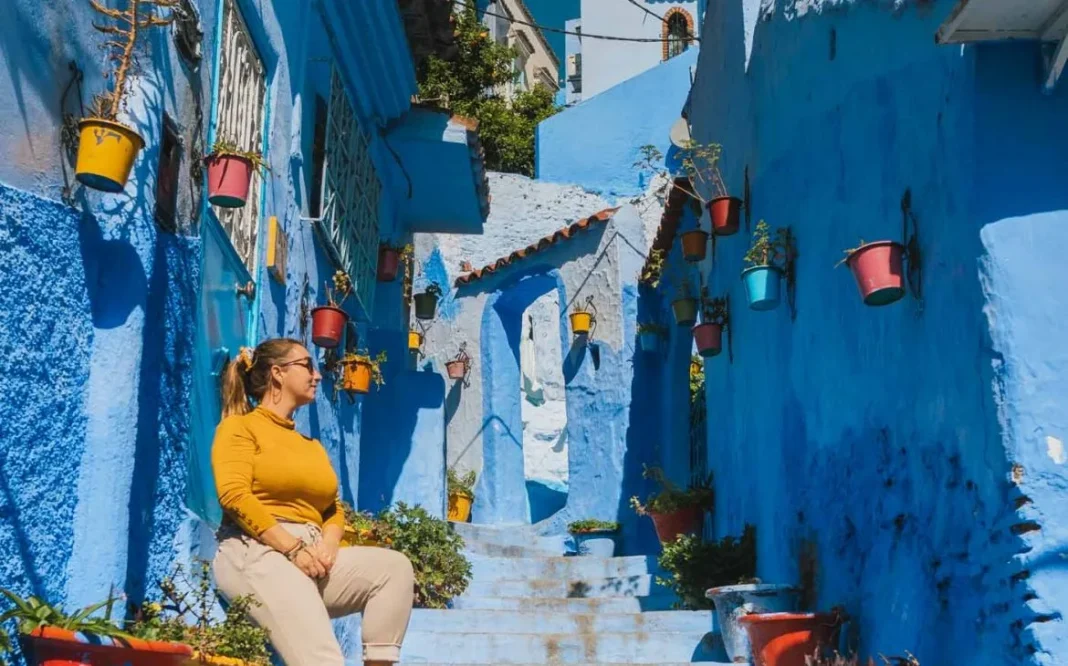 Chefchaouen : La ville marocaine exceptionnelle classée dans le top 3 mondial Rue colorée de Chefchaouen avec murs bleus et pots de fleurs.
