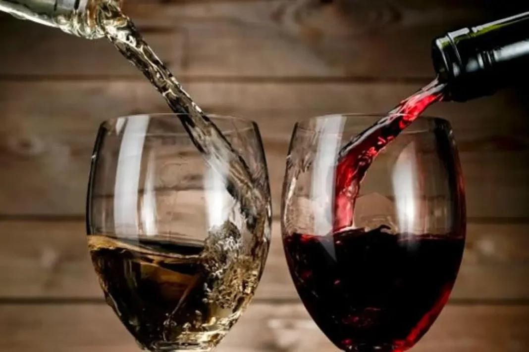 Verres de vin rouge et blanc en train d'être remplis.