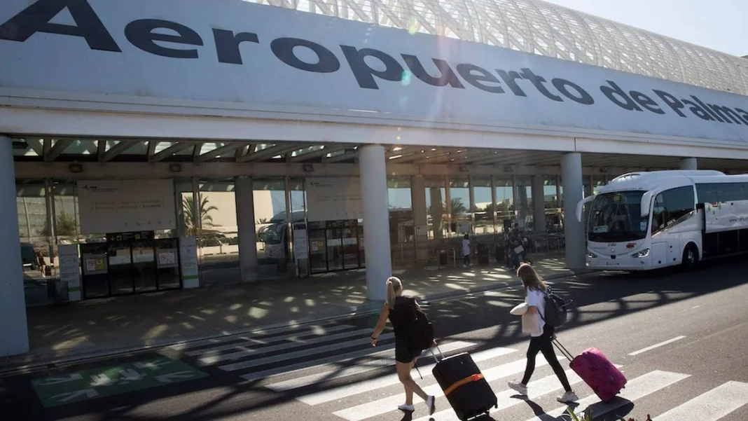 Voyageurs avec valises à l'aéroport de Palma.