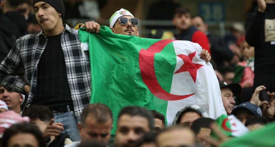 Supporters algériens avec drapeau national Supporters algériens avec drapeau national lors d'un événement sportif.