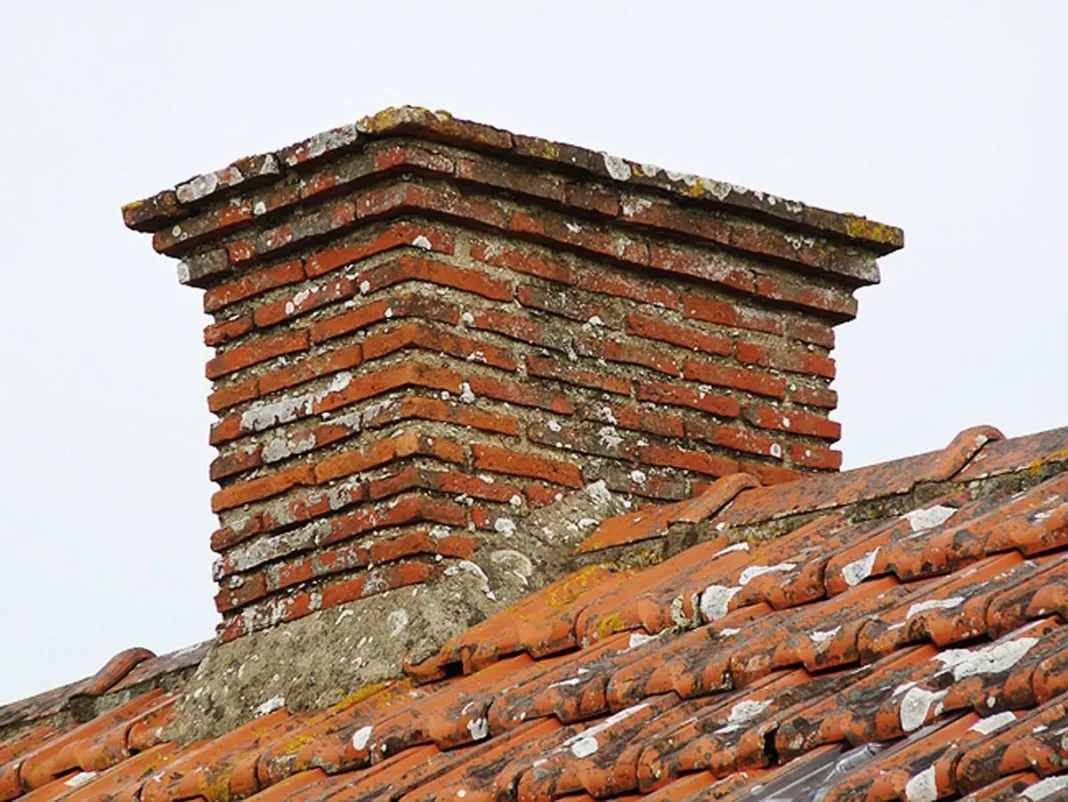 Cheminée en briques sur le toit d'une maison ancienne.