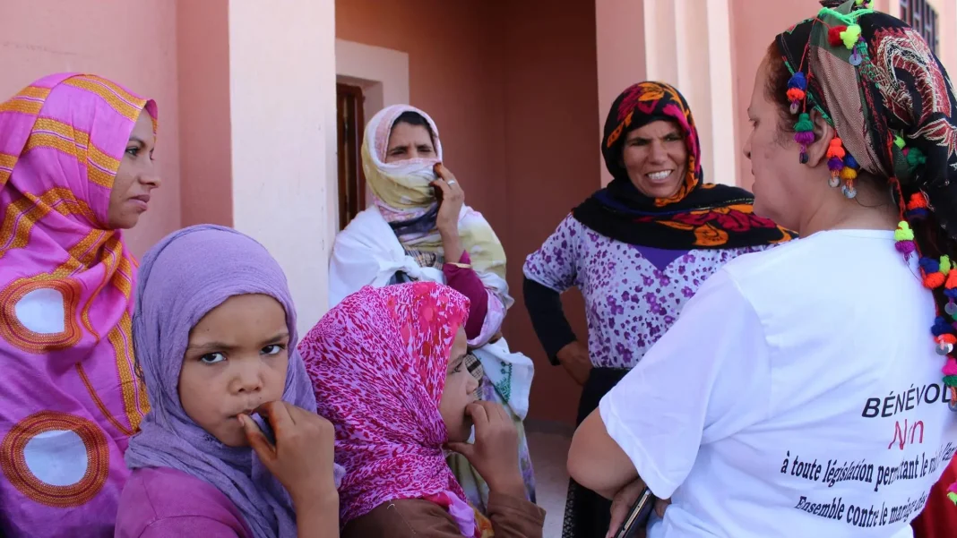 Mariage précoce au Maroc : Quand la tradition se moque du droit des jeunes filles marocaines Groupe de femmes et enfants marocains lors d'une discussion communautaire.