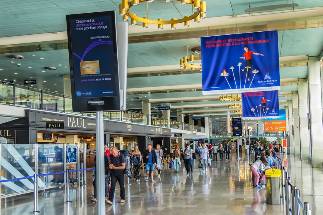 Aéroport avec voyageurs et affiches publicitaires Aéroport animé avec voyageurs et affiches publicitaires colorées.
