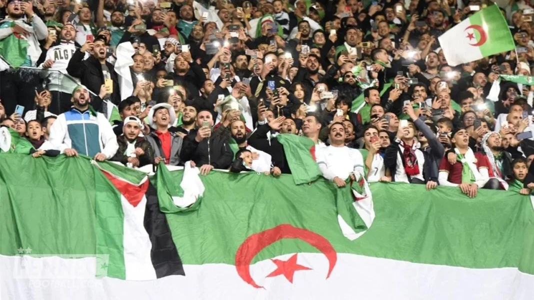 Qualif Mondial 2026 : l’Algérie à la tête du groupe G Supporters algériens avec drapeaux et écharpes lors d'un match.