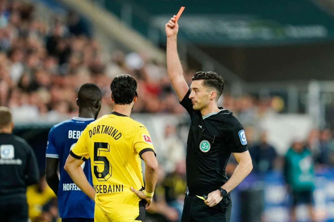 Carton rouge pour Ramy Bensebaini. Le coach du BVB s’emporte contre le Fennec Arbitre montrant un carton rouge à Ramy Bensebaini lors d'un match de football.
