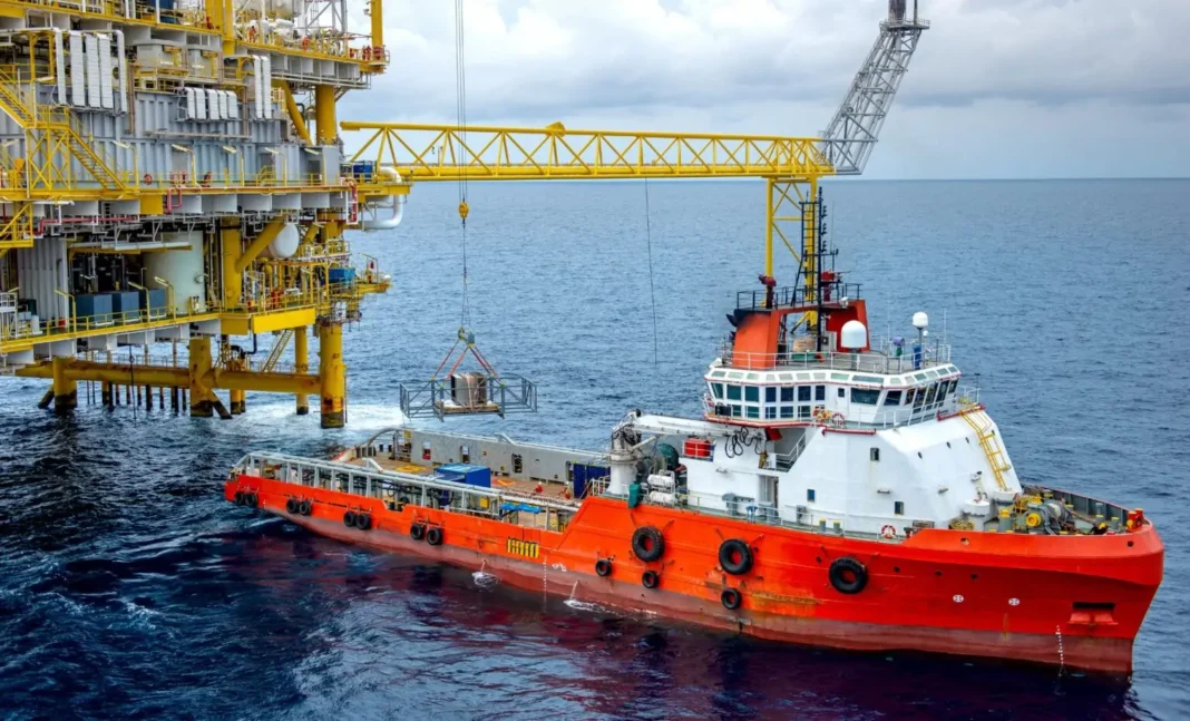 Le cours du pétrole grimpe à une vitesse hallucinante Remorqueur en mer près d'une plateforme pétrolière en mer.