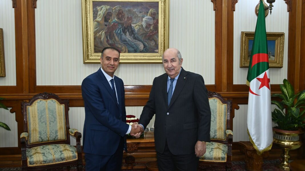 Tebboune reçoit le Président de la FAF, Walid Sadi Tebboune et le président de la FAF se serrent la main dans un bureau officiel.