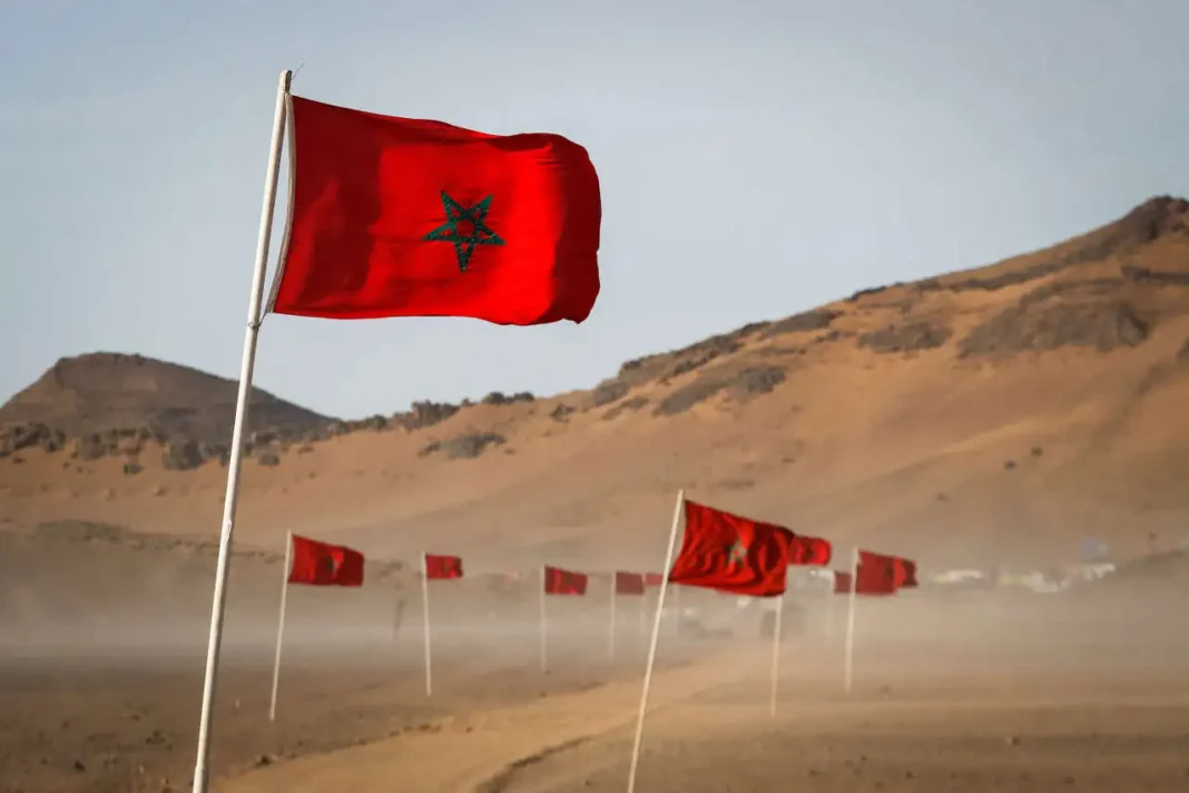 L’Algérie et le Polisario échouent une fois de plus dans leur opposition au développement du Sahara marocain Drapeau marocain flottant dans le désert avec montagnes en arrière-plan.