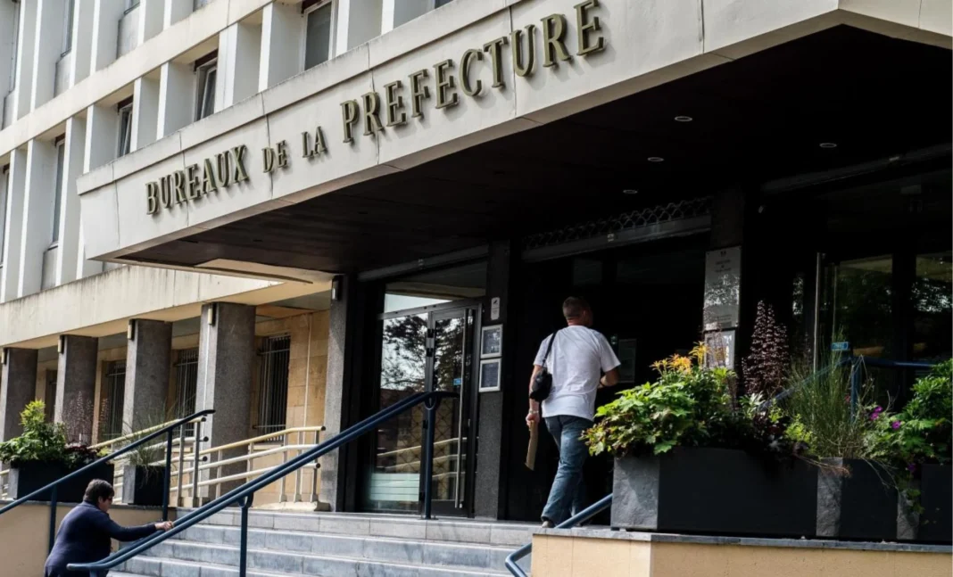 Problèmes avec votre demande de titre de séjour à la préfecture ? Voici les étapes à suivre Personne entrant dans la bureau de la préfecture pour demande de titre de séjour.