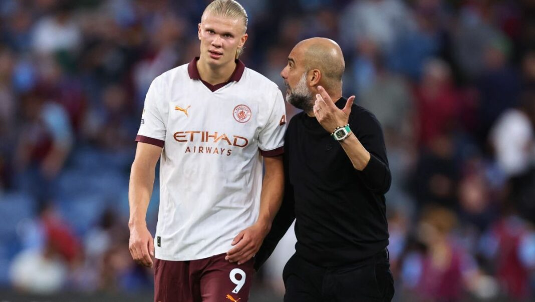 Joueur de Manchester City en discussion avec l'entraîneur lors du match.