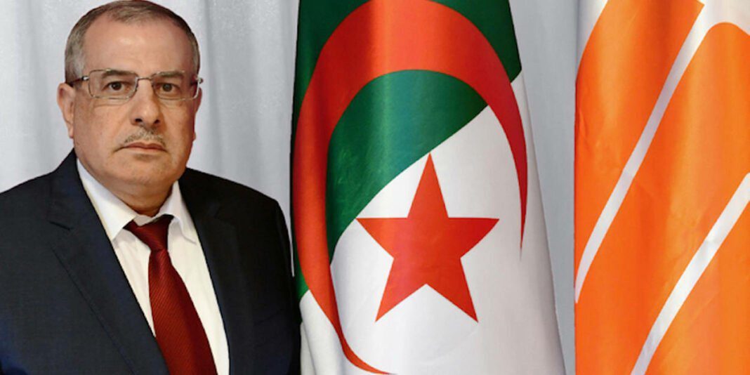Rachid Hachichi : Le nouveau PDG de Sonatrach – Un homme d’expérience Rachid Hachichi devant le drapeau algérien et le logo de Sonatrach.
