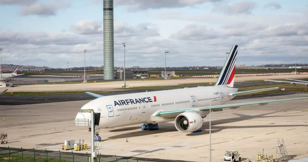 Avion Air France stationné à l'aéroport avec terminal en arrière-plan.