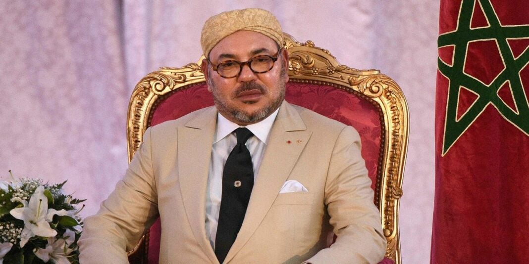 Le Maroc prône la diplomatie pour résoudre le conflit Israélo-Palestinien Homme politique marocain en costume beige, siège royal, drapeau du Maroc en arrière-plan.