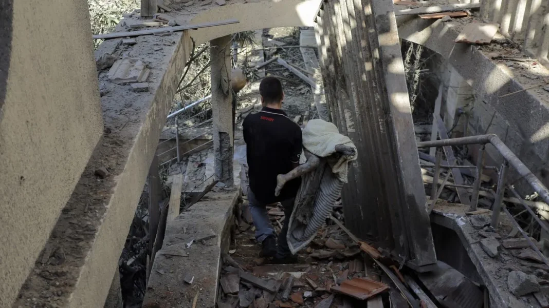 Bombardements à Gaza: que faut-il retenir? Personne inspectant les débris d'un bâtiment détruit à Gaza.
