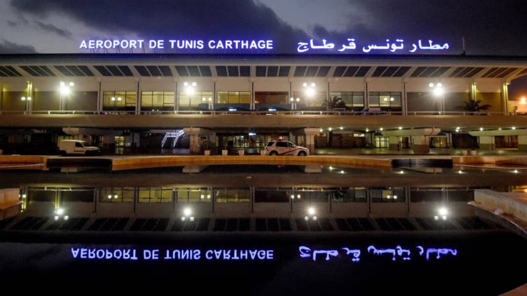 Aéroport de Tunis Carthage la nuit Vue nocturne de l'aéroport de Tunis Carthage avec signalisation en français et arabe.