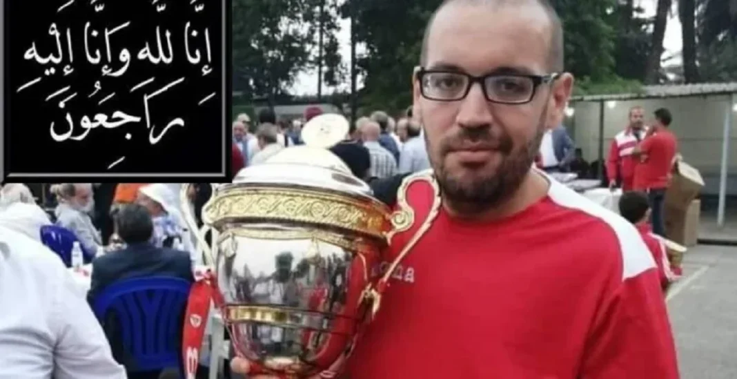 Homme avec lunettes tenant un trophée lors d'un rassemblement public.