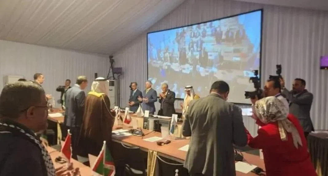 L’Algérie boycotte le discours du Président de l’UIP en signe de soutien à la Palestine Réunion diplomatique avec discours en grand écran, participants en discussion.