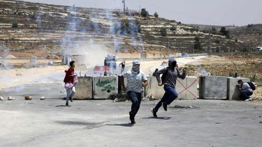 Manifestants palestiniens face aux barricades et à la police.
