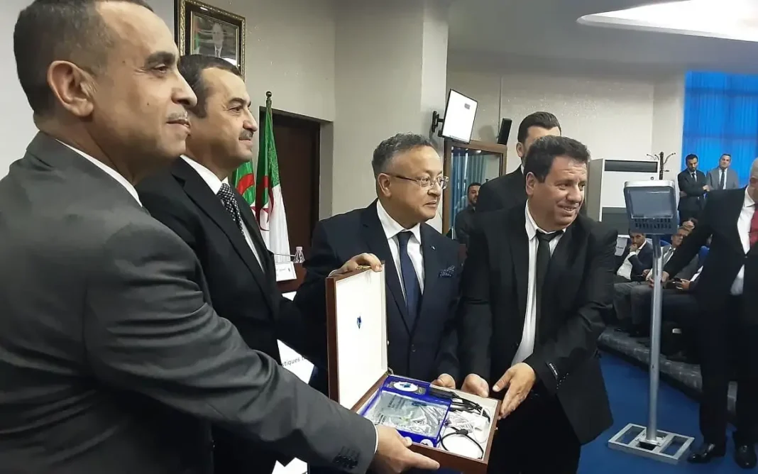 Algérie : Livraison de quatre batteries lithium et détecteur monoxyde carbone Cinq hommes en costume lors d'une cérémonie de remise de batteries lithium.