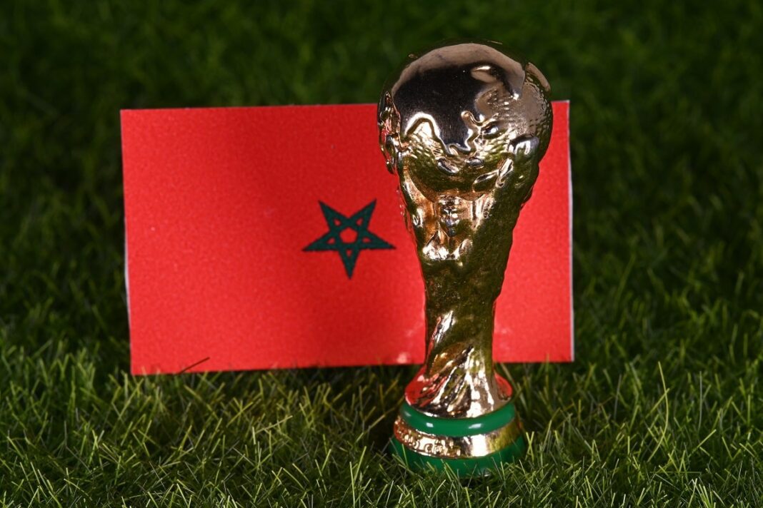 Mondial 2030 : Le Qatar s’engage à soutenir le Maroc dans la co-organisation Trophée de la Coupe du Monde avec drapeau marocain en arrière-plan.