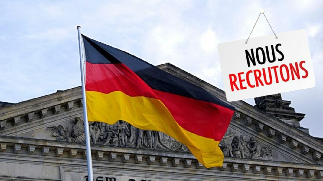 Drapeau allemand devant un bâtiment officiel avec panneau de recrutement.