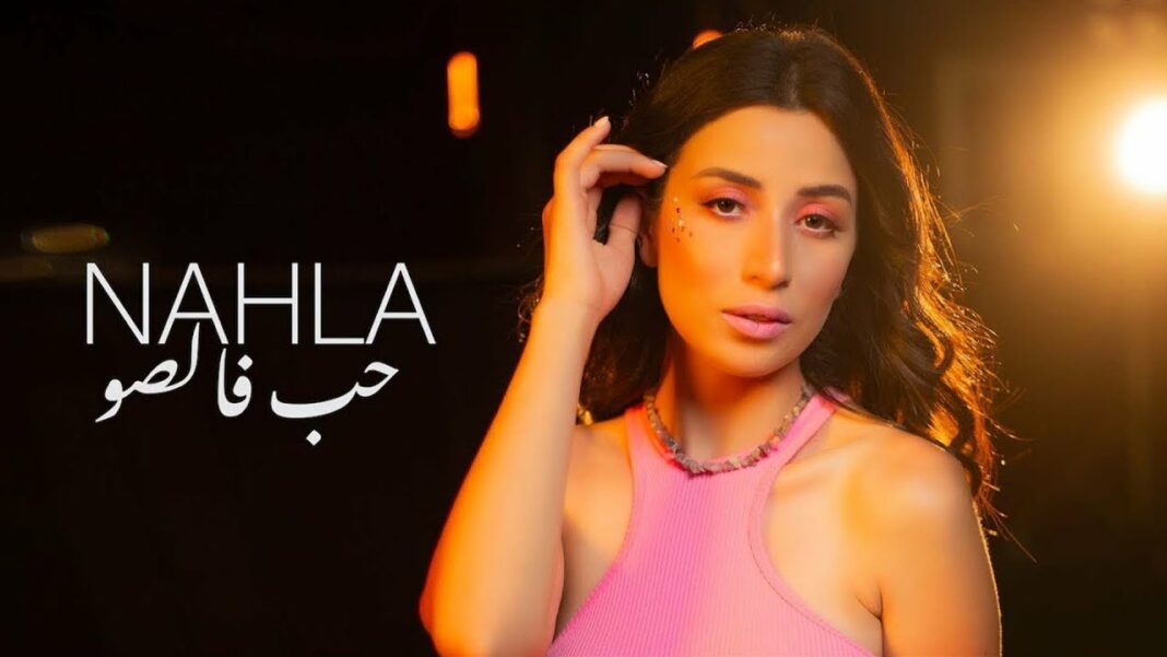 Nahla TV accuse Ennahar TV de manipulation Jeune femme avec maquillage et vêtement rose, portrait en studio.
