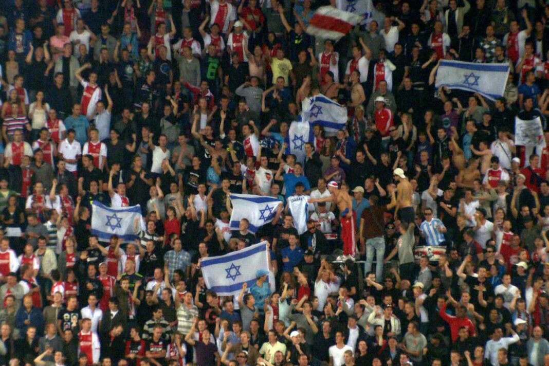 Tottenham Stadium : Interdiction des Drapeaux Israéliens et Palestiniens dans les tribunes Foule de supporters agitant des drapeaux israéliens dans les tribunes.