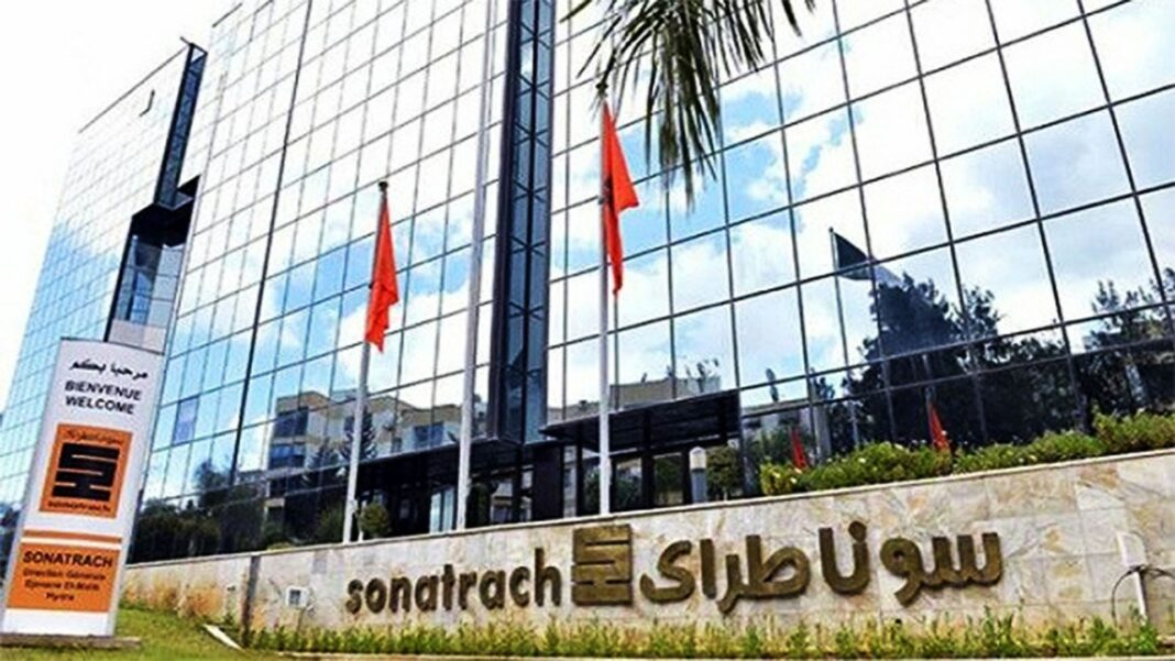 Sonatrach et le CNRST lancent un concours de publication scientifique en Algérie avec une prime de 1,5 million de DA » Façade vitrée du siège de Sonatrach avec drapeaux algériens.