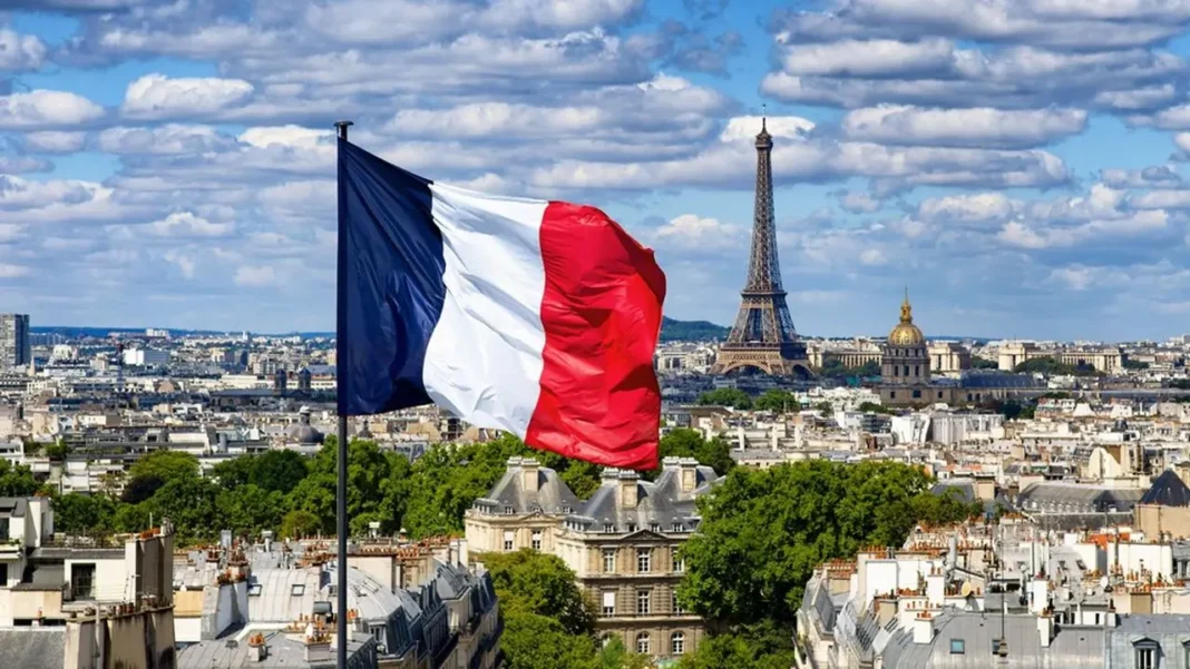Drapeau français sur Paris Drapeau français flottant avec la Tour Eiffel en arrière-plan.