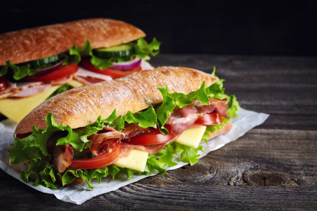 Amende de 2.000 € : une voyageuse sanctionnée pour la présence d’un Sandwich dans ses bagages Sandwich avec légumes, viande et fromage sur pain croustillant.