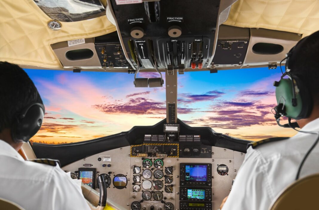 Cockpit d'avion EasyJet avec pilotes en vol au coucher du soleil.