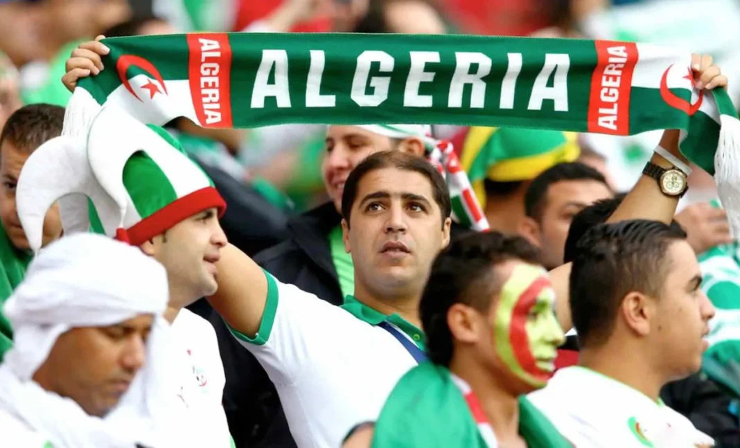 Supporters algériens avec écharpe et face peinte en vert, blanc et rouge.