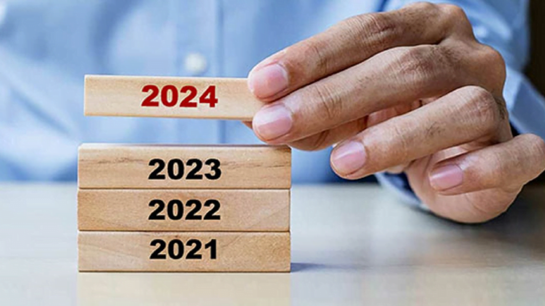 Algérie: cap vers une croissance économique de 4,2 % en 2024 Main ajustant des blocs de bois avec année 2024 en rouge.