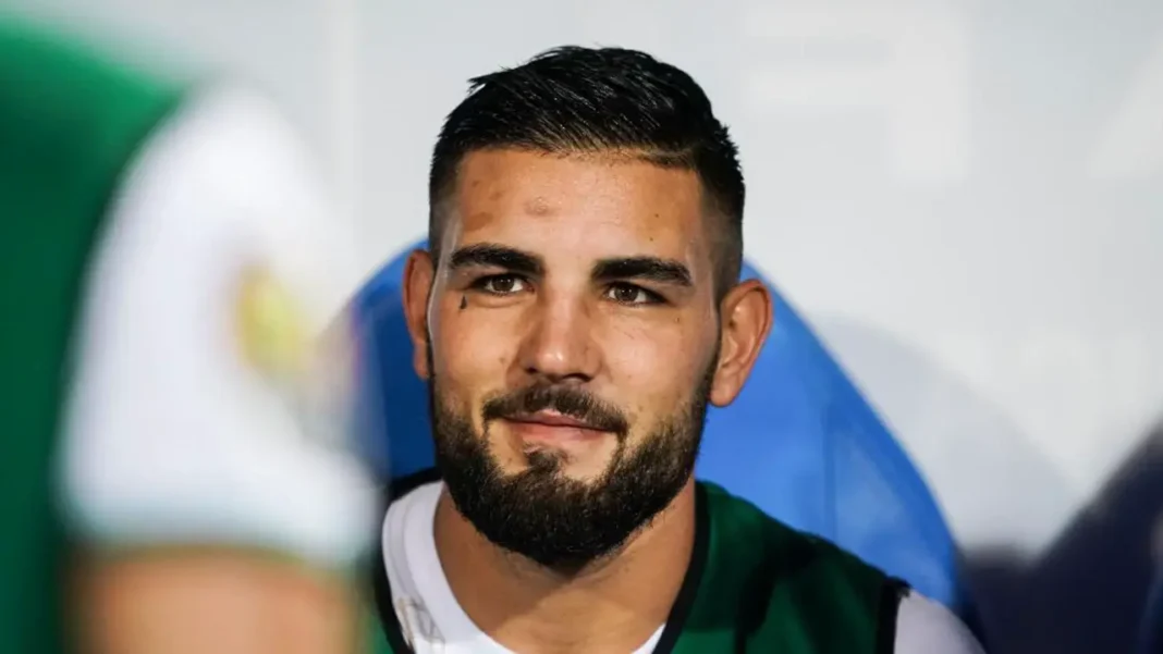 Andy Delort, joueur de football algérien, souriant sur le terrain.