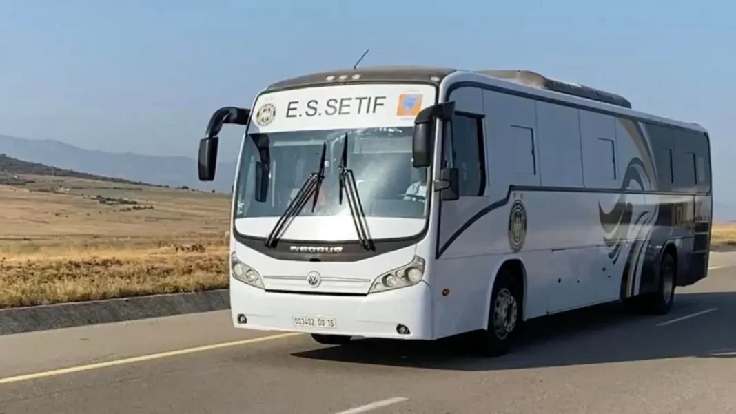 Bus blanc de l'équipe de Sétif sur la route en plein jour.