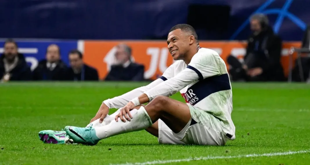 Kylian Mbappé lors d'un match Kylian Mbappé assis sur le terrain après une blessure.