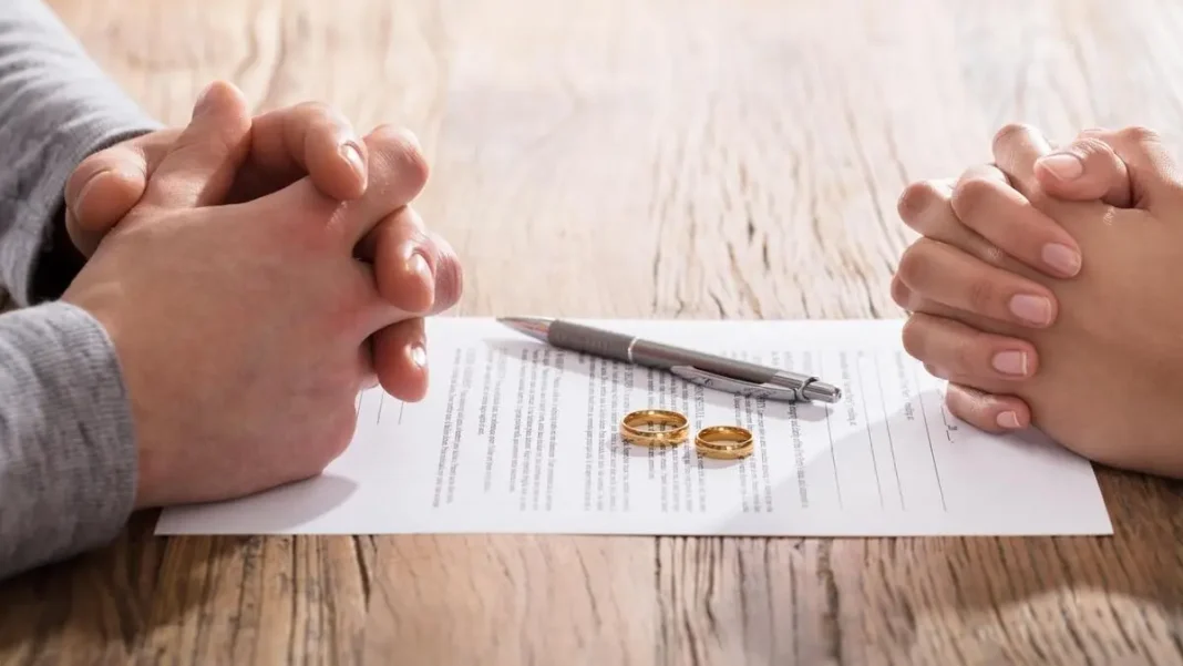 Pays affichant le plus de taux de divorces en Afrique: l’Algérie présente Deux personnes en discussion avec des alliances sur une table en bois.