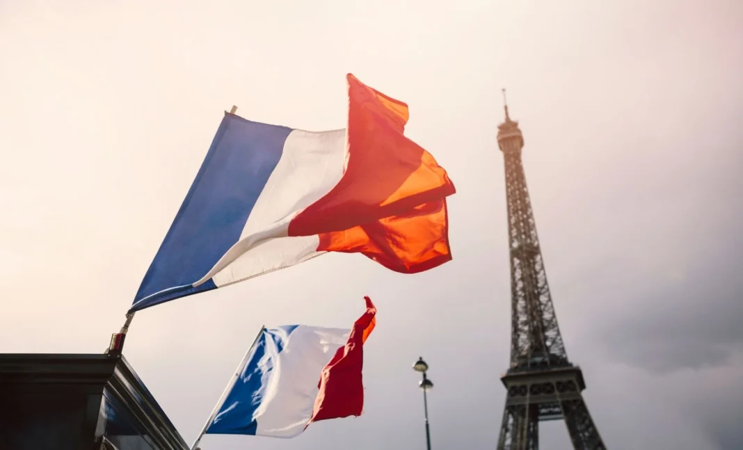 France: l’Algérie compte le plus grand nombre de personnalités influentes Drapeaux français flottant avec la Tour Eiffel en arrière-plan.