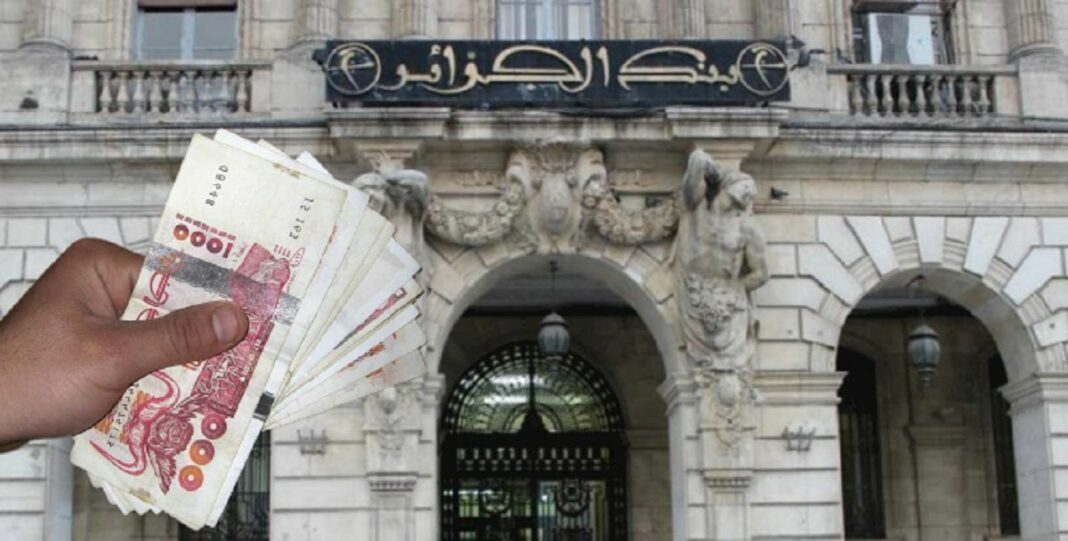 La Banque d’Algérie prévoit de lancer une nouvelle pièce de 10 dinars en acier inoxydable Main tenant des billets de banque devant la Banque d'Algérie.