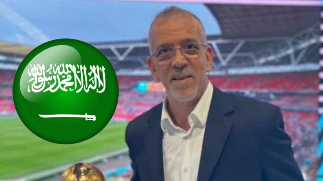 Hafid Derradji, au cœur d’une controverse avec les Saoudiens Hafid Derradji dans un stade avec drapeau saoudien en arrière-plan.