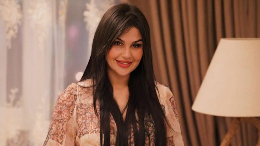 Ahlam Ammouri souriante, annonce sa grossesse dans un cadre chaleureux.