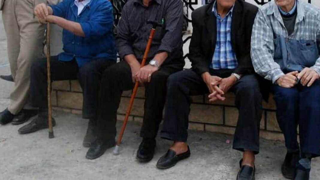 Allocation de chômage pour les séniors en Algérie : Ce qu’il faut savoir pour 2024 Groupe de seniors assis sur un banc, en attente d'informations sociales.