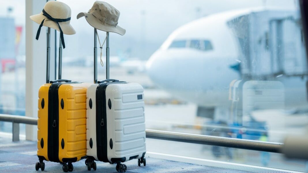 Bagages avec chapeaux à l'aéroport près d'un avion.