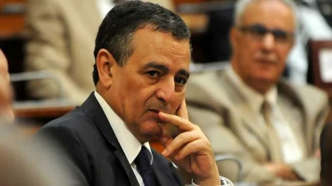Affaire Bouchouareb : Maintien du gel des avoirs suisses dans un scandale de corruption Homme en costume en réunion, réflexion intense, contexte de corruption.