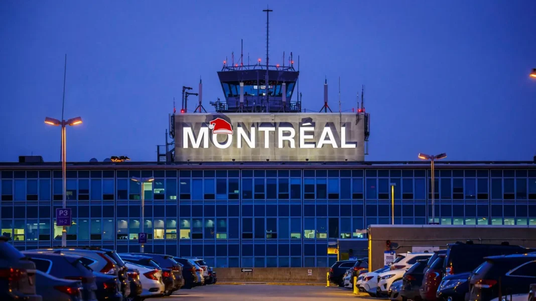 Vue de nuit de l'aéroport Montréal avec panneau lumineux.