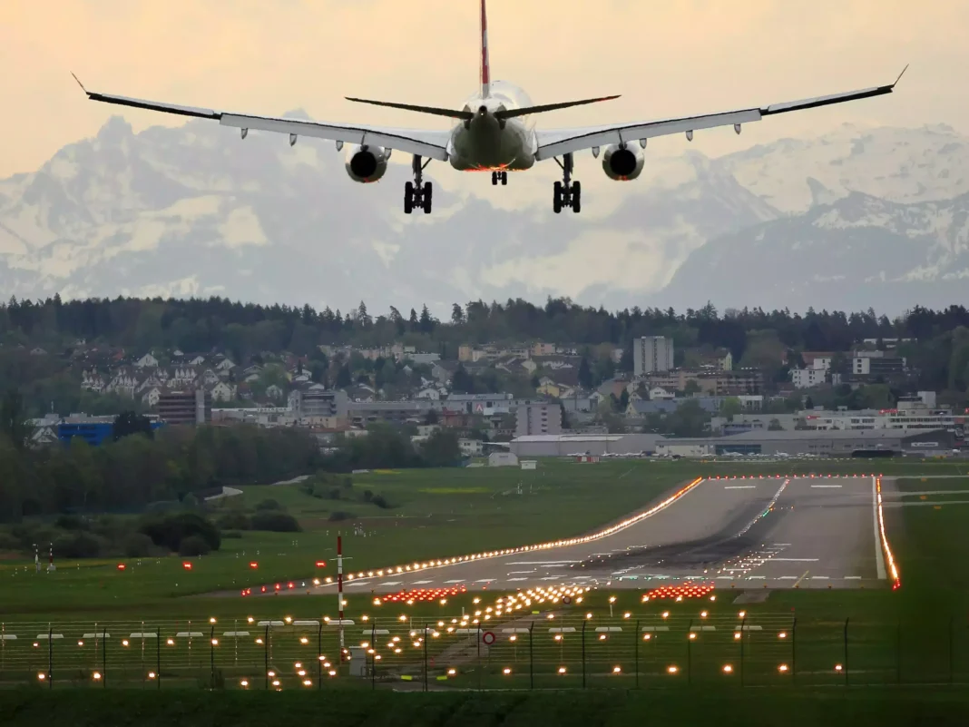 Attention aux voyageurs algériens en France : Tous les vols annulés le 26 juillet 2024 Avion en approche pour atterrir sur une piste d'aéroport avec montagnes en arrière-plan.