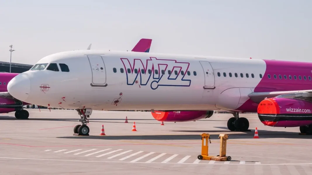 Avion Wizz Air blanc et rose stationné à l'aéroport.