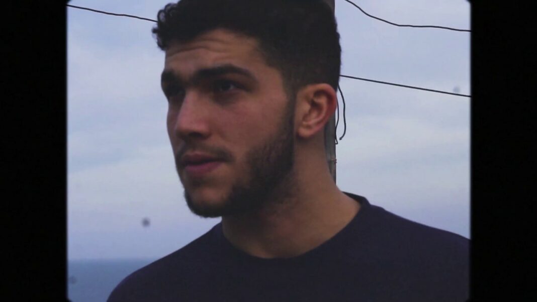 Découvrez TIF, la nouvelle star montante du Rap originaire d’Alger en 2023 Jeune homme avec barbe et cheveux bouclés, regardant vers la gauche.