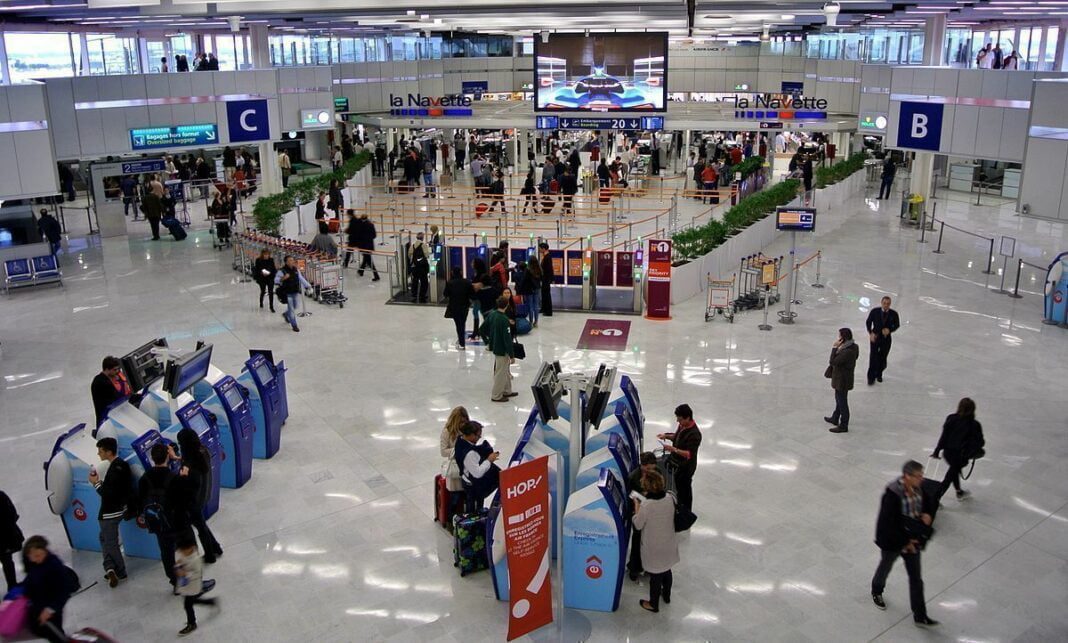 Refus de prise en charge à l’aéroport : Un appel à la tolérance face à la discrimination Vue de l'aéroport avec passagers, comptoirs et écrans d'information.