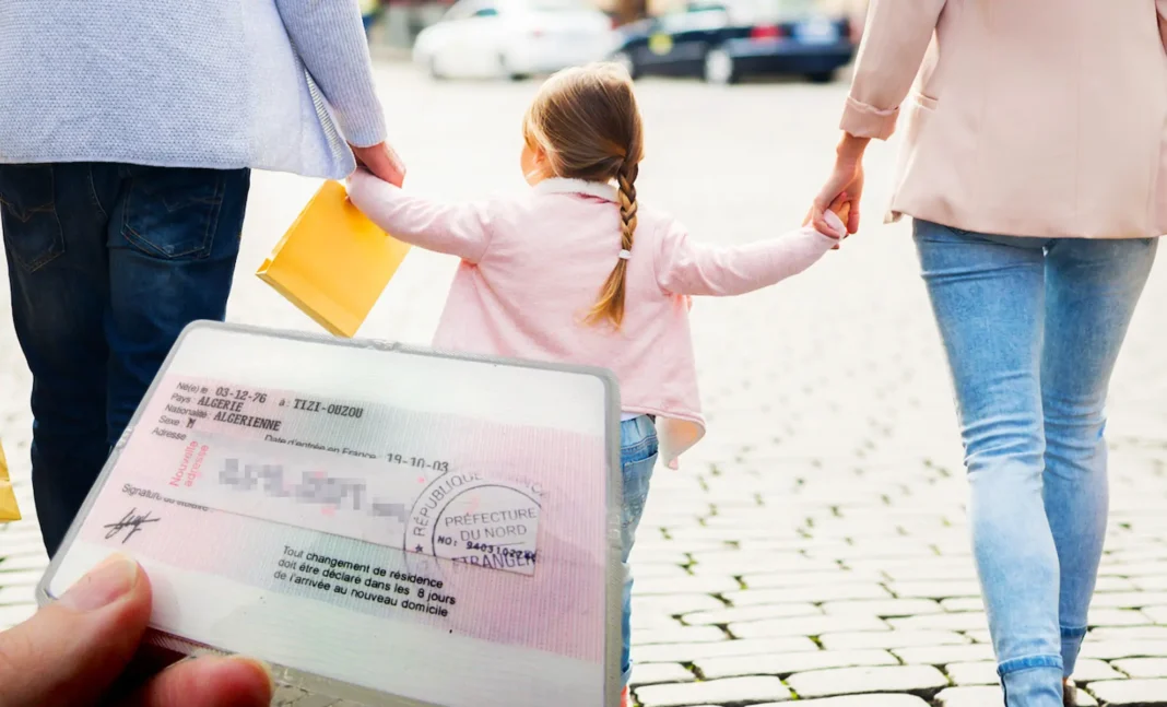 Réforme du regroupement familial en France : nouvelles exigences affectant les demandeurs Algériens Famille avec enfant tenant un document officiel de voyage ou de résidence.